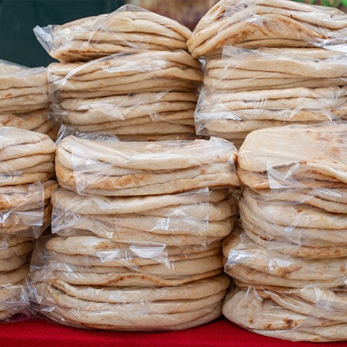 flour tortillas in plastic bags stacked on a table