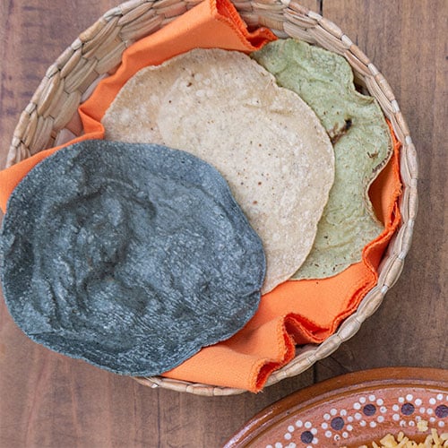 a colorful variety of tortillas in a woven basket