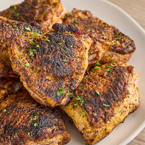Blackened meat sitting on a white plate