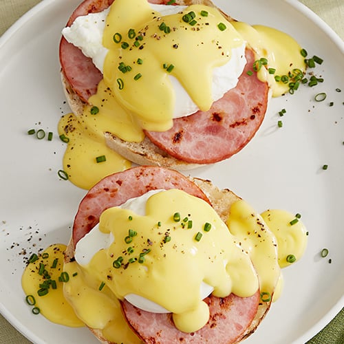 Two sandwiches with hollandaise sauce on top