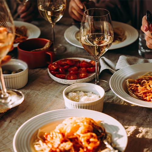 Group shot of food dishes and wine glasses in an nice restaurant