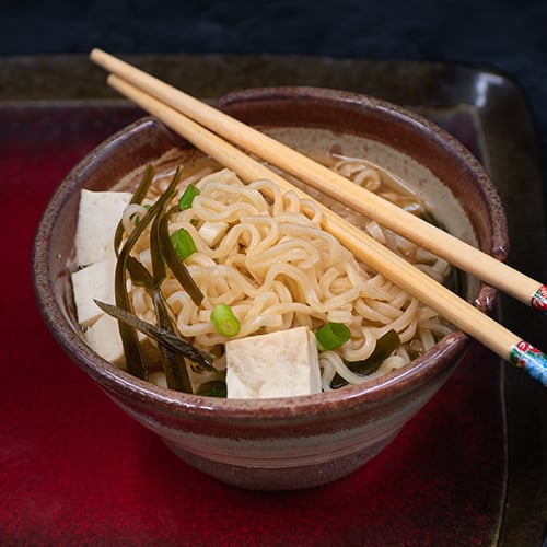 A bowl of ramen with chopsticks