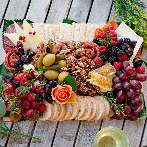 a full charcuterie board filled with meats, cheese, fruits and bread
