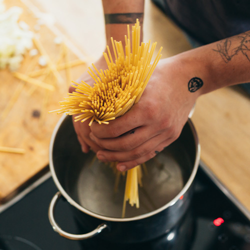 close up of man preparing pasta