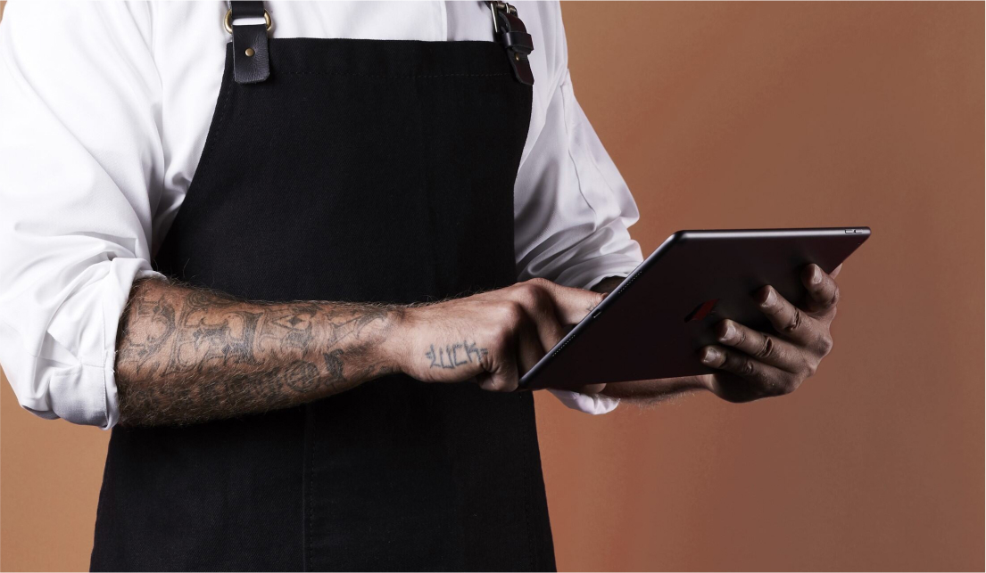 man with an apron holding a tablet