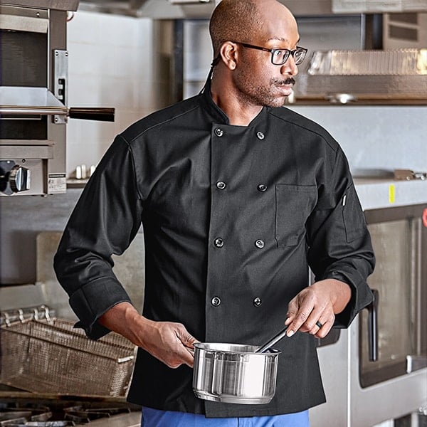 chef with glasses sirring a sauce pot