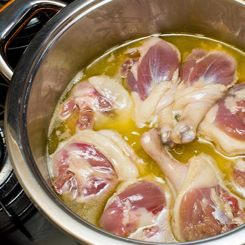 Duck confit during the preparation in a pot