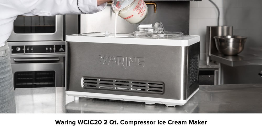 Waring WCIC20 countertop ice cream maker in a commercial kitchen as a person pours ice cream mixture into the machine.