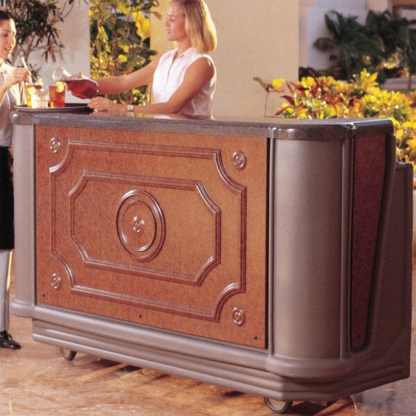 A woman standing behind a Cambro Designer Series portable bar counter serving drinks.