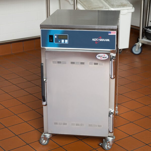 An Alto-Shaam 500-S mobile holding cabinet on wheels in a kitchen.