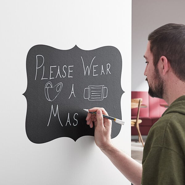 A man writing on a Choice decorative vinyl chalkboard label with a black marker.