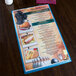 A Menu Solutions Sky Hamilton heat sealed menu board on a table.