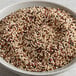 A bowl of mixed white, black, and red quinoa seeds.