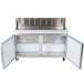 An Avantco stainless steel sandwich prep table with two open doors.