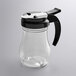 A clear polycarbonate teardrop syrup server with a black lid.