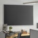 A 72" x 48" black wall-mount magnetic chalkboard with aluminum frame on a wall.